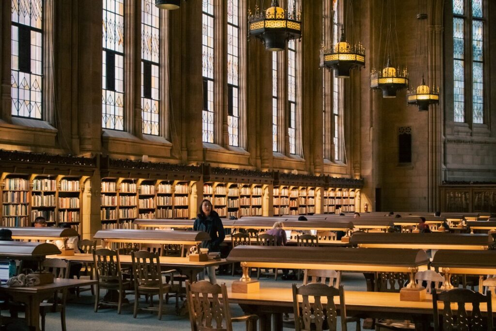 Large library with a person sitting at a table.